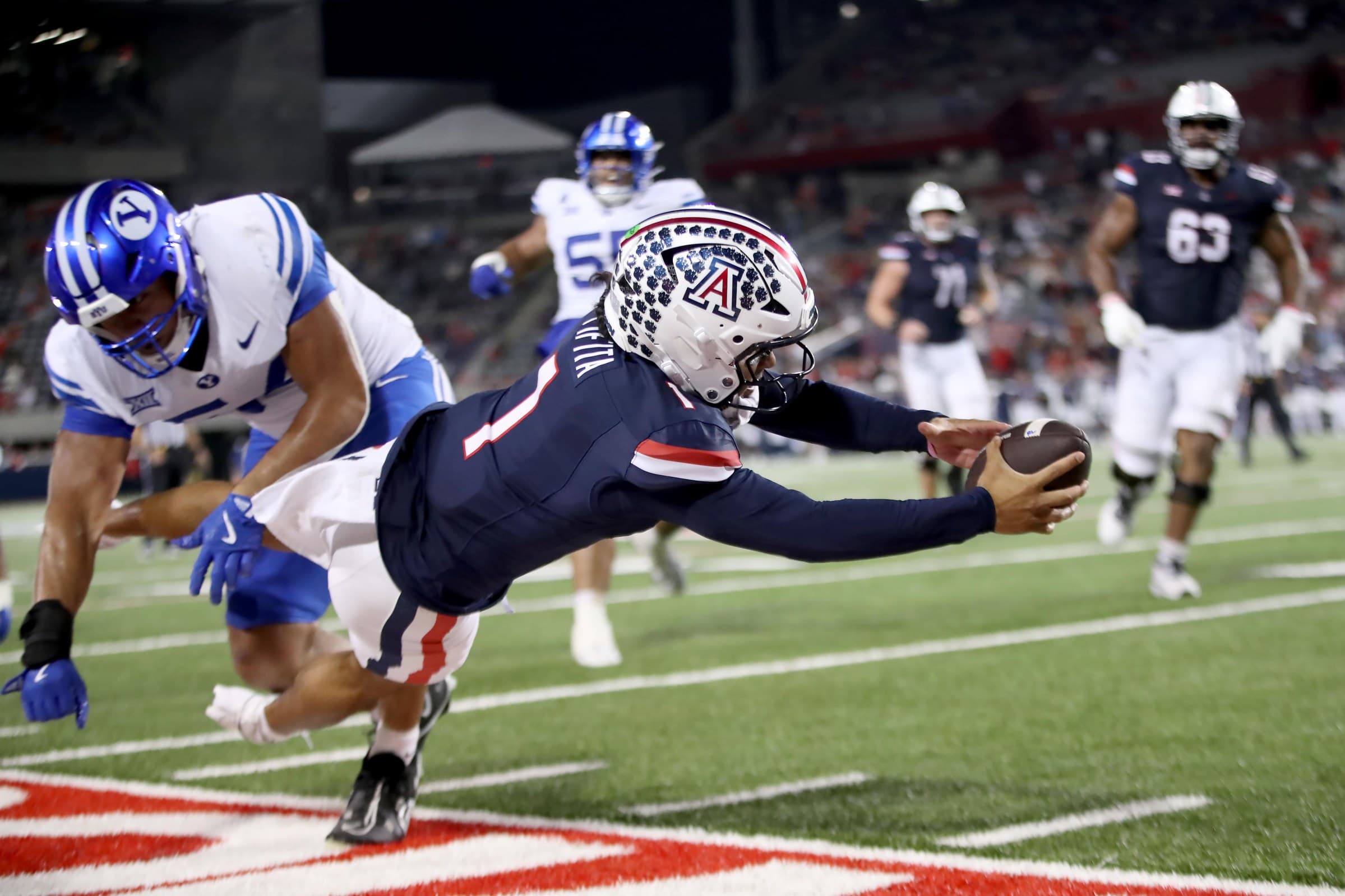 Arizona offensive player dives forward reaching for the ball near the goal line — an example of the explosive, finish‑at‑the‑pylon playmakers the Wildcats hope to feature from their running backs in 2026 training camp.