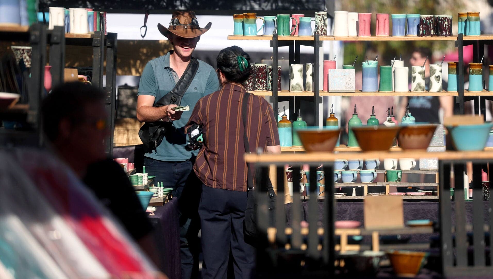 Shoppers browse handmade pottery at an outdoor arts market in Tucson, one of the nearly 40 events taking place across the city this weekend, June 25-28.