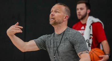 A college coach gestures while evaluating prospects at the Section 7 showcase in Mesa, Ariz., the same event Louisville staff attended to scout 2028 targets.