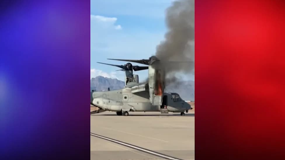 Close view of an MV-22B Osprey on the ground with flames and dark smoke pouring from the right nacelle during a Mesa, Arizona training exercise; crew evacuated and no injuries reported.
