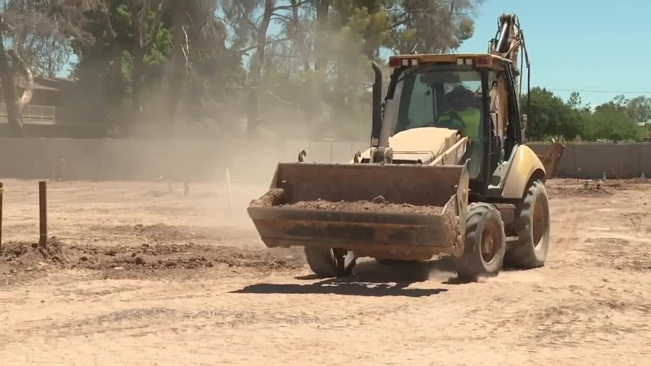Construction equipment working on a dirt lot in Mesa as site preparation gets underway for the Main Street market restaurant‑incubator project.