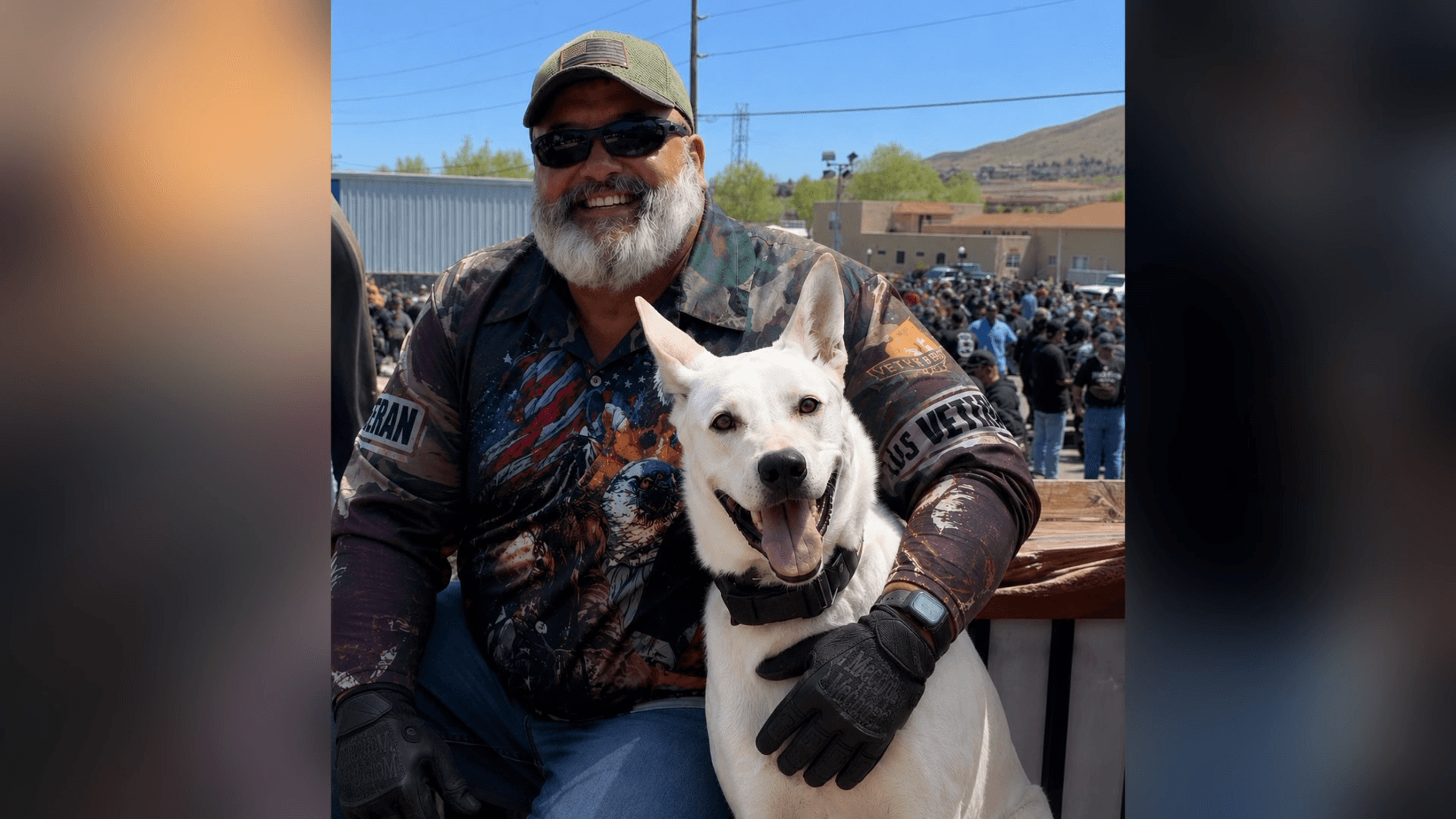 A military veteran smiles with his dog at an outdoor event; he later received a $500,000 settlement after a DUI arrest despite a clean blood test.