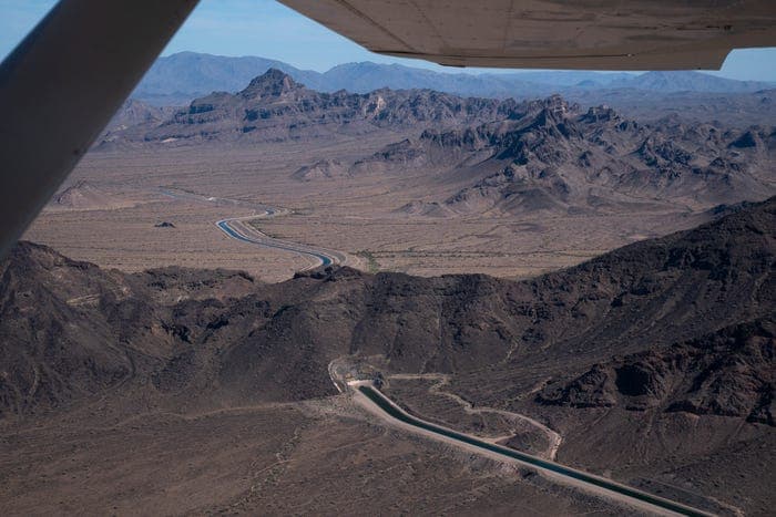 Aerial view of the Central Arizona Project canal approaching a tunnel entrance west of Tonopah, Arizona, showing the aqueduct cutting through desert terrain (June 3, 2026).