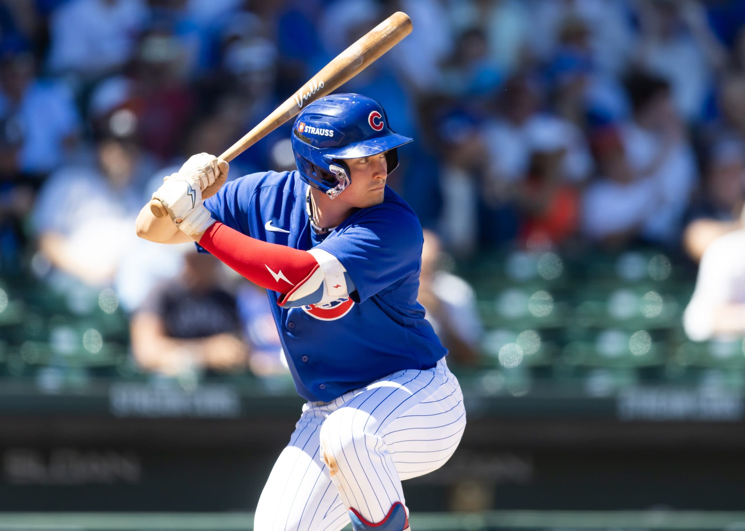 19-year-old Cubs prospect at the plate during spring action, showing a poised batting stance in the team’s blue uniform.