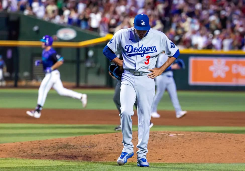 A Dodgers pitcher stands on the mound as a Diamondbacks runner rounds the bases in the tense matchup at Chase Field during the Aug. 8, 2026 game.
