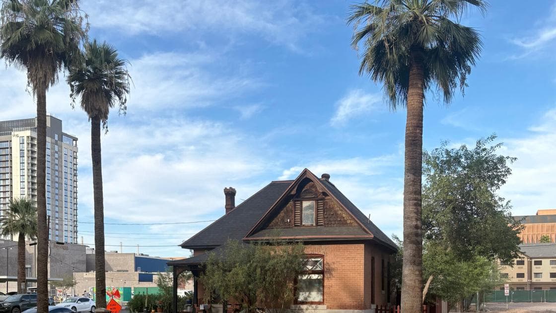 The Louis Emerson pre‑statehood home in Phoenix’s Churchill area, framed by palm trees with newer development visible behind — the historic property at the center of ASU’s legal bid for the land.