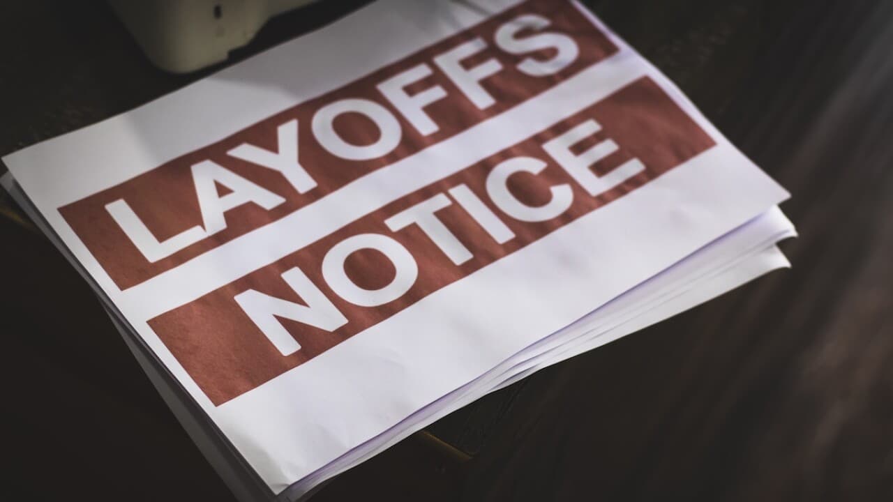 Stack of printed 'LAYOFFS NOTICE' sheets — illustrative of the 98 employees affected by Infineon's closure of its Mesa plant.