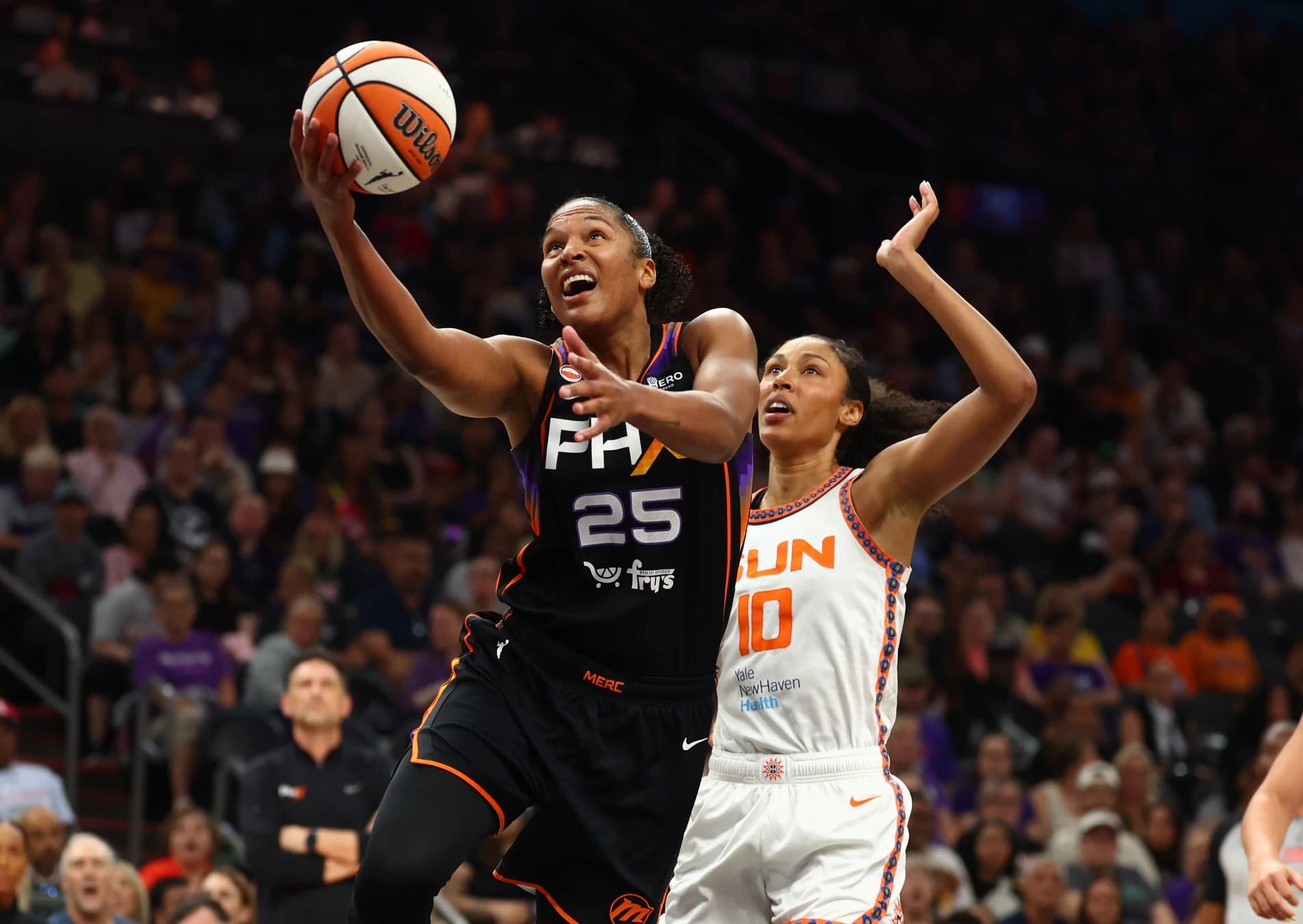 Phoenix Mercury player (black) drives to the basket as a Connecticut Sun defender (white) contests the shot during the July 19, 2026 matchup in Phoenix.