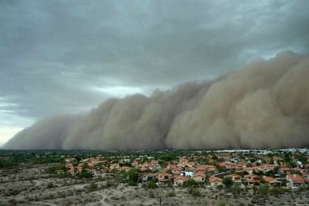 A towering dust wall (haboob) sweeps over suburban Phoenix, reducing visibility and contributing to outages and travel delays across the metro area.