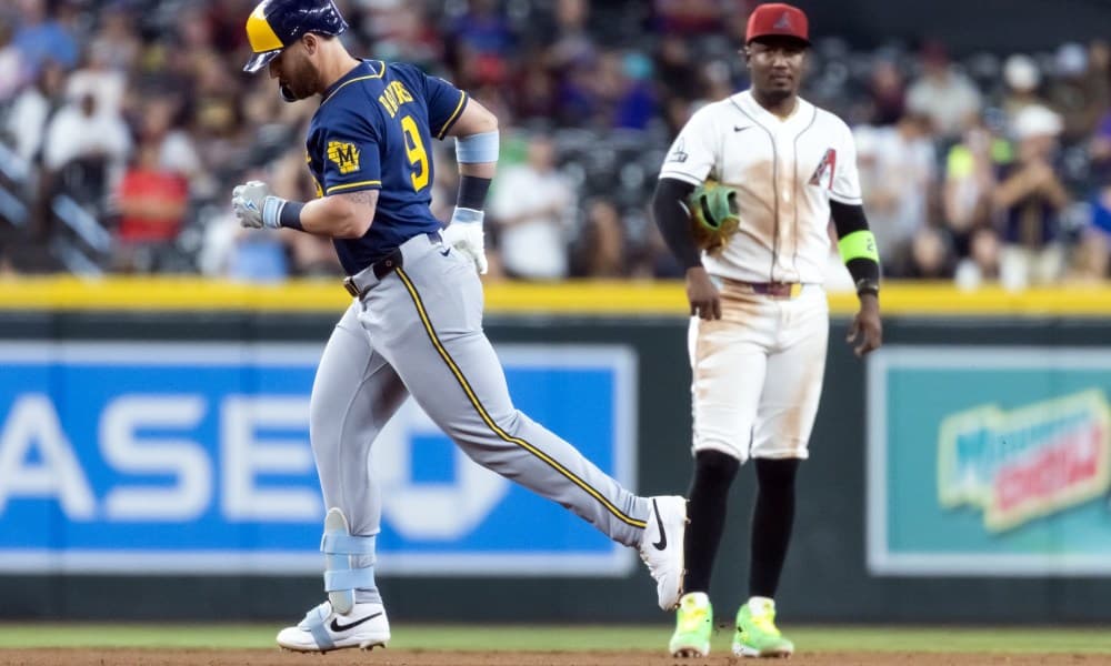 A Brewers hitter rounds the bases while a Diamondbacks infielder watches in the game that stretched to 11 innings and ended in a 7-4 win for Milwaukee.