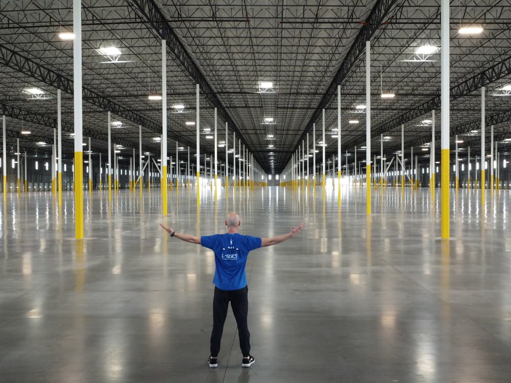 Interior view of the vast, 1.1 million-square-foot warehouse in Tolleson, showing the column grid and finished concrete floor — part of the GO|99 North megawarehouse project Willmeng Construction recently broke ground on to help address Phoenix's shortage of large-scale logistics space.