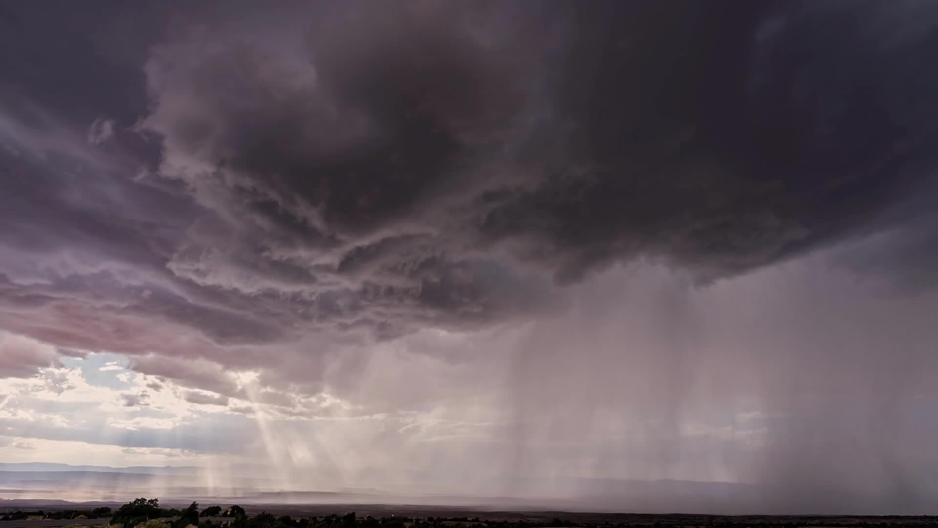 Heavy monsoon clouds and rain build over the region — conditions meteorologists say can coincide with and influence dust storm activity across the Valley.