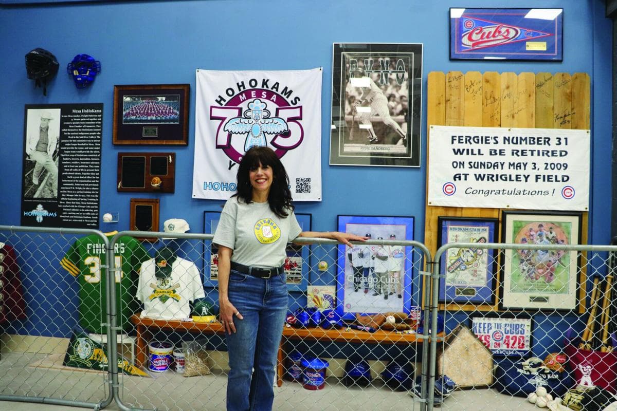 The artist stands inside the museum’s exhibit space amid memorabilia and banners where her works will be featured.