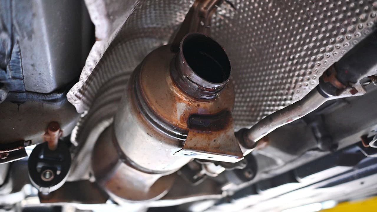 A catalytic converter mounted under a vehicle — police say officers recovered 14 stolen converters after the Mesa traffic stop.