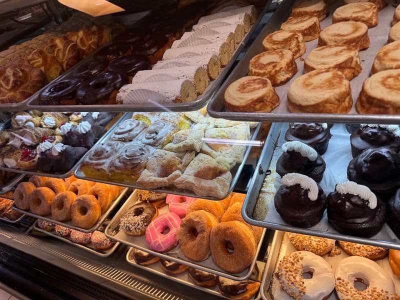 Interior display case at the bakeshop showing an assortment of pastries and donuts — a look at the bakery offerings that accompany the tamales highlighted in the 2026 feature.