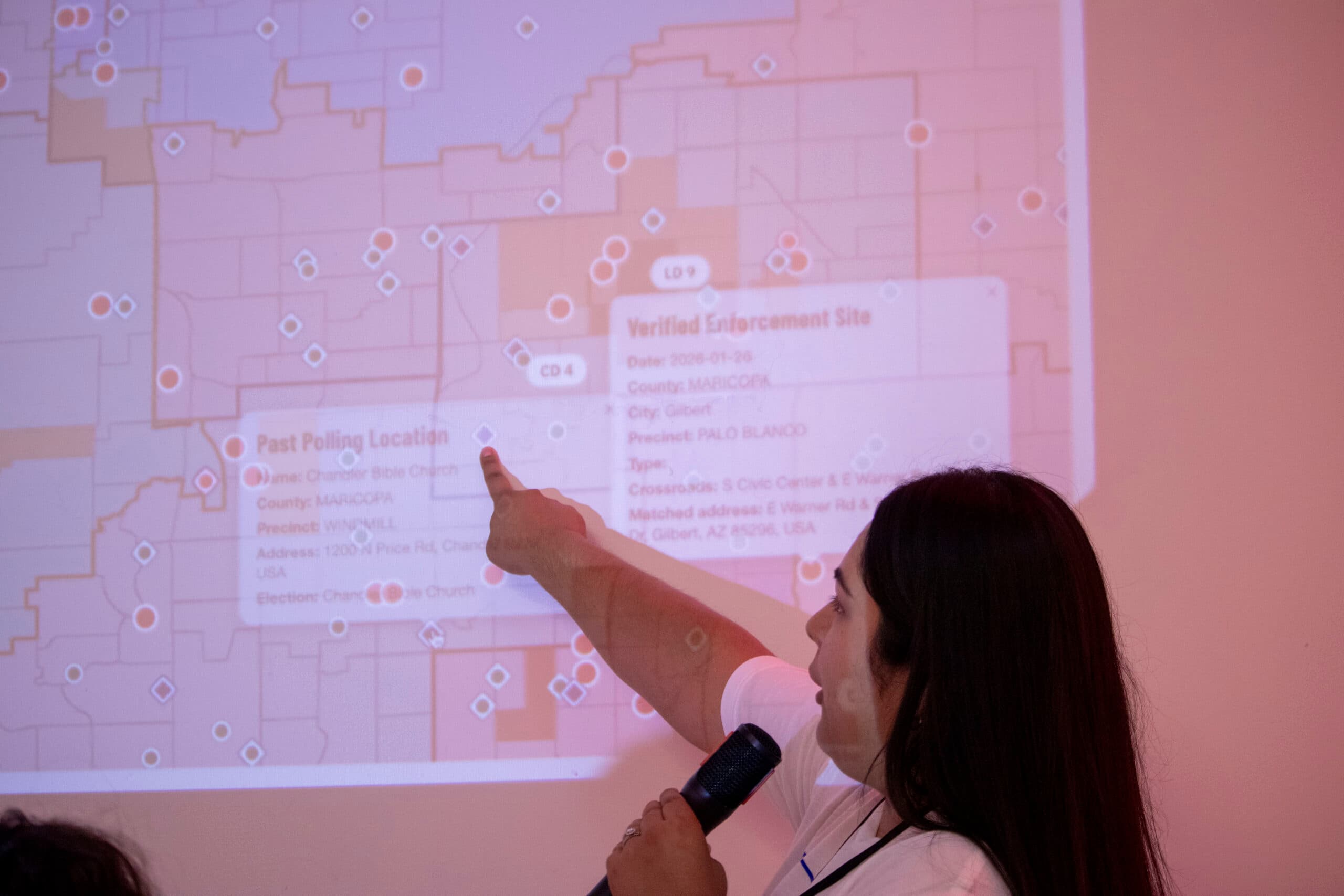 A trainer points to a projected map of reported enforcement and polling locations during a Congreso 2026 session on how observers should respond if federal agents appear at voting sites.