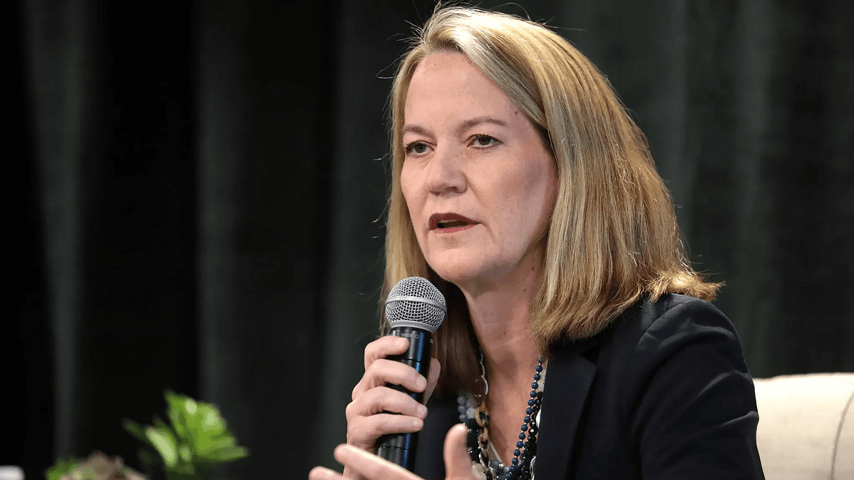 Arizona official speaking into a microphone at a public event after the state reached a settlement to drop regulation of school-choice programs.