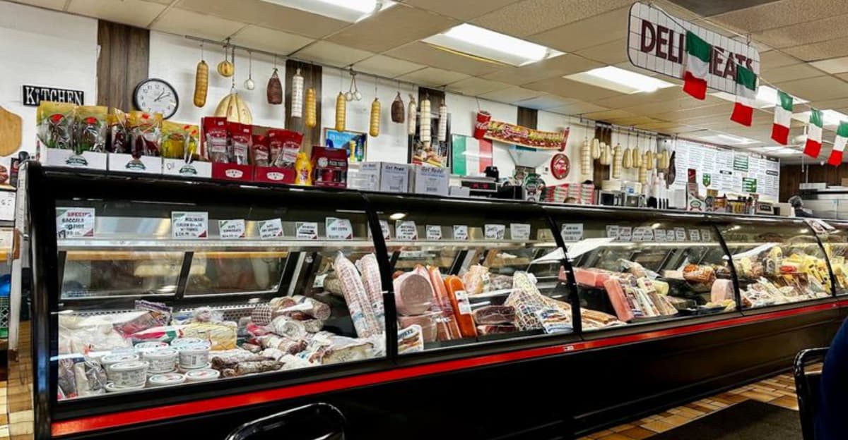 Deli counter at the humble Phoenix Italian shop, displaying cured meats and cheeses — the same counter where locals line up for the eatery’s much‑talked‑about pie.