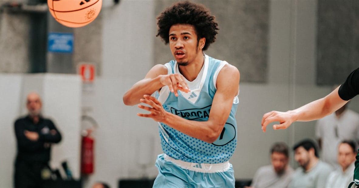 No. 15-ranked guard in action at the adidas Eurocamp in Italy, threading a pass while wearing a light-blue 'EUROCAMP' game jersey.