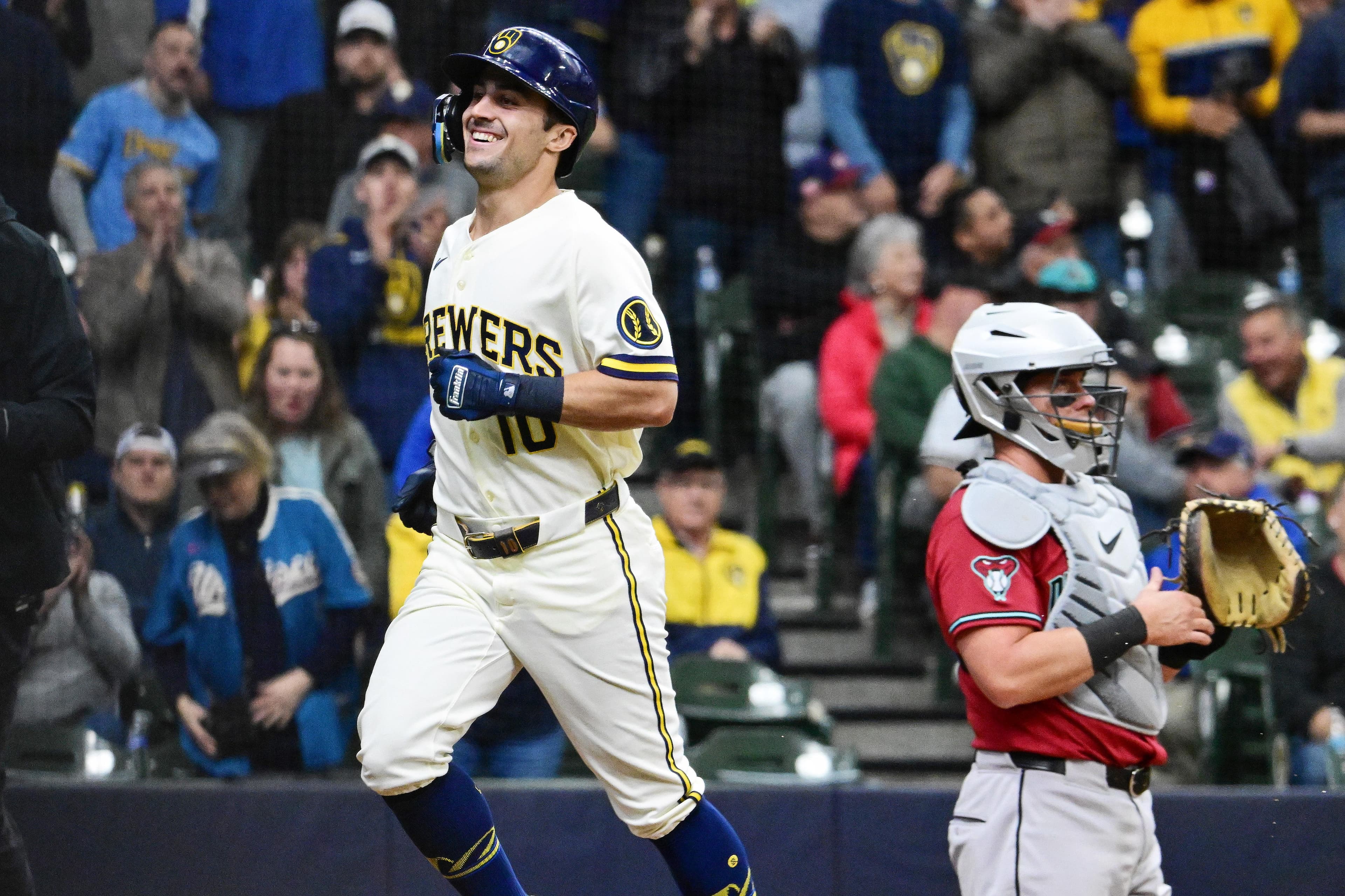 Milwaukee Brewers player celebrates while running past an Arizona Diamondbacks catcher during the series opener at Chase Field in Phoenix.