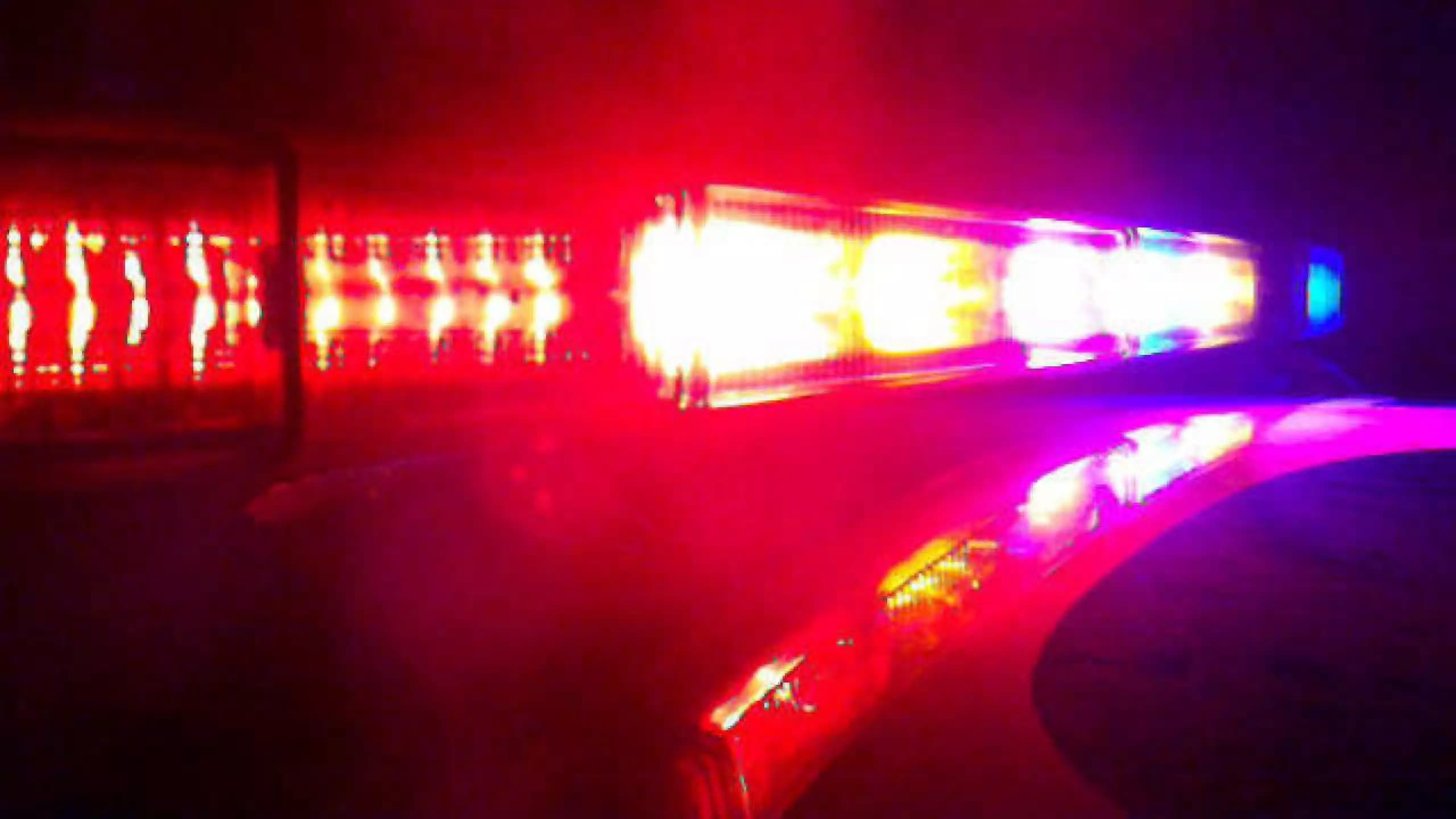 Police vehicle lights flash at the scene after a deadly crash that temporarily closed the intersection of Cooper and Merrill roads in Gilbert.