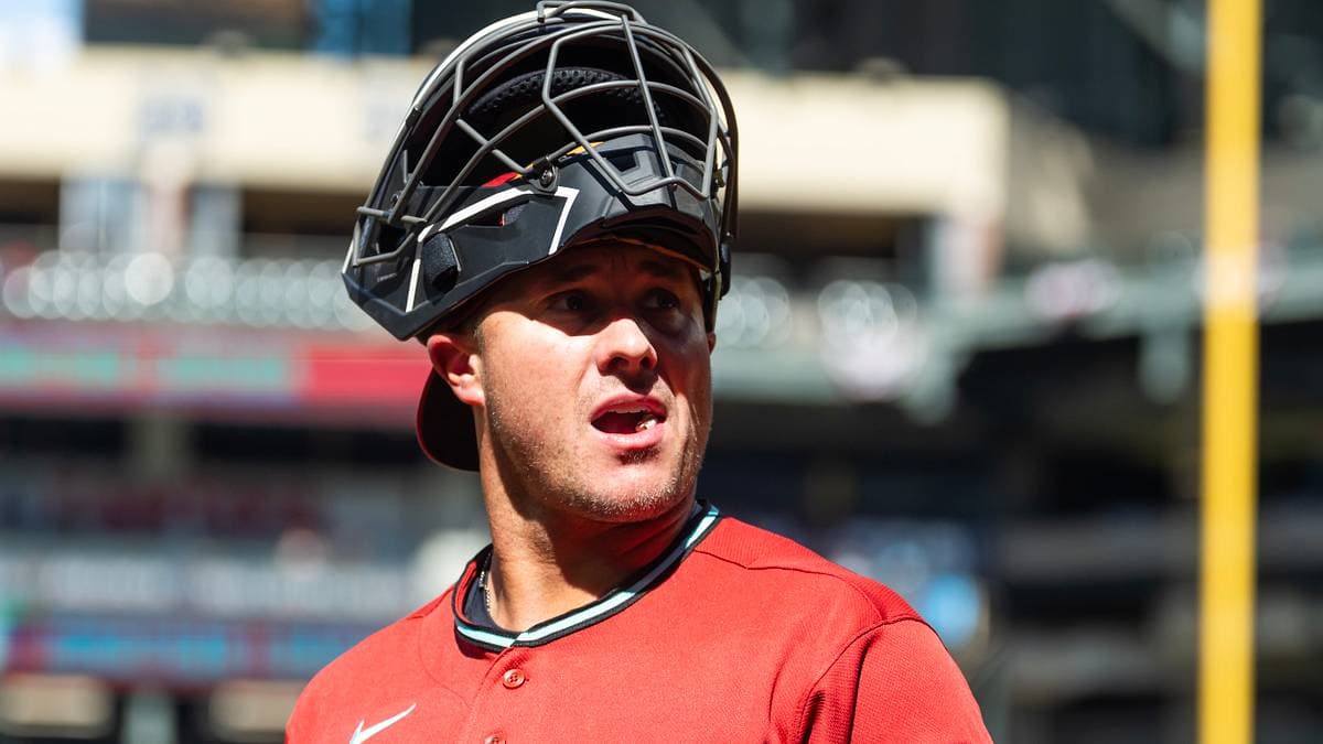 James McCann with his catcher's mask pushed up on his head, watching the action during an Arizona Diamondbacks game at Chase Field — his timely return boosts the D-backs' catching depth.