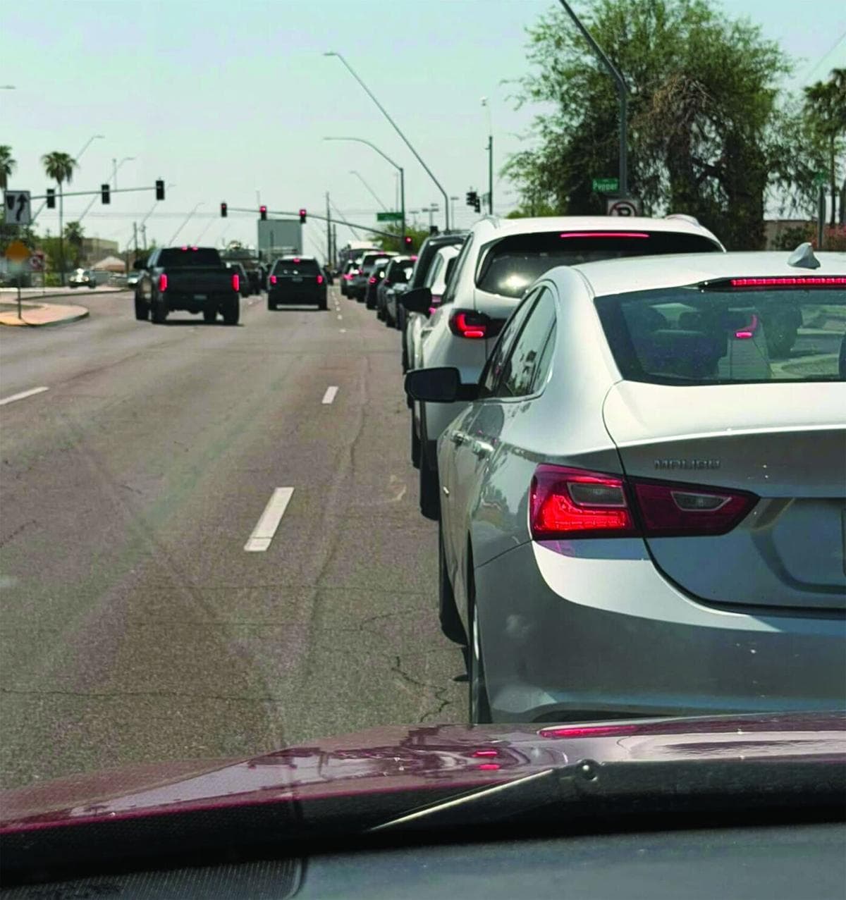A line of vehicles queued on a Mesa street, illustrating traffic backups tied to EVIT busing delays reported by the Mesa Tribune.