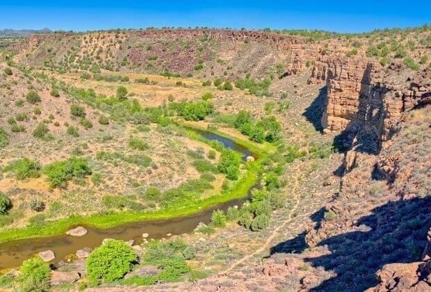 A desert river winds through an Arizona canyon, illustrating the arid landscapes and water-stress factors referenced in the state's environmental report card.