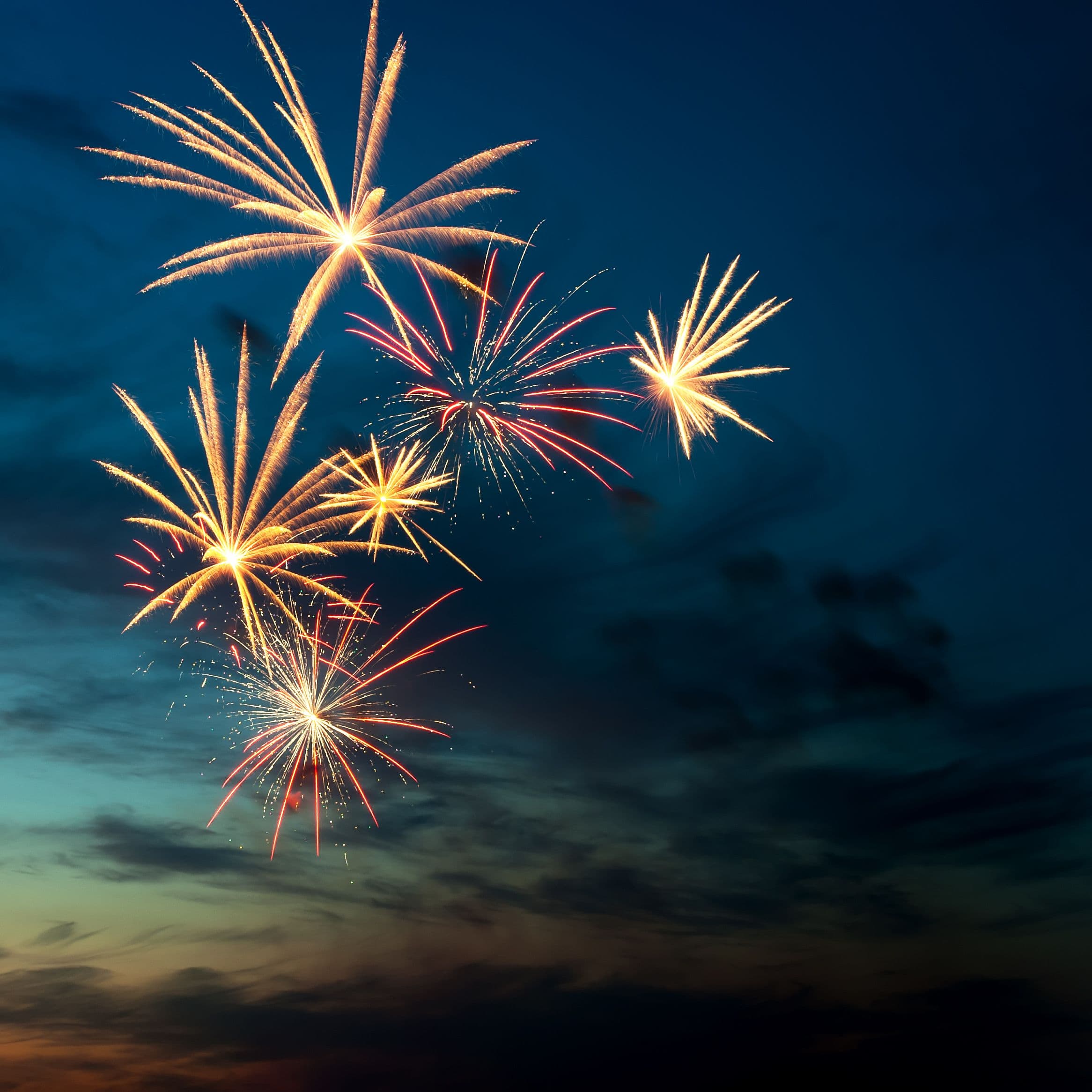 Fireworks explode over a twilight sky — the kind of displays Phoenix officials moved to prohibit within one mile of desert parks and mountain preserves under Stage 1 restrictions.