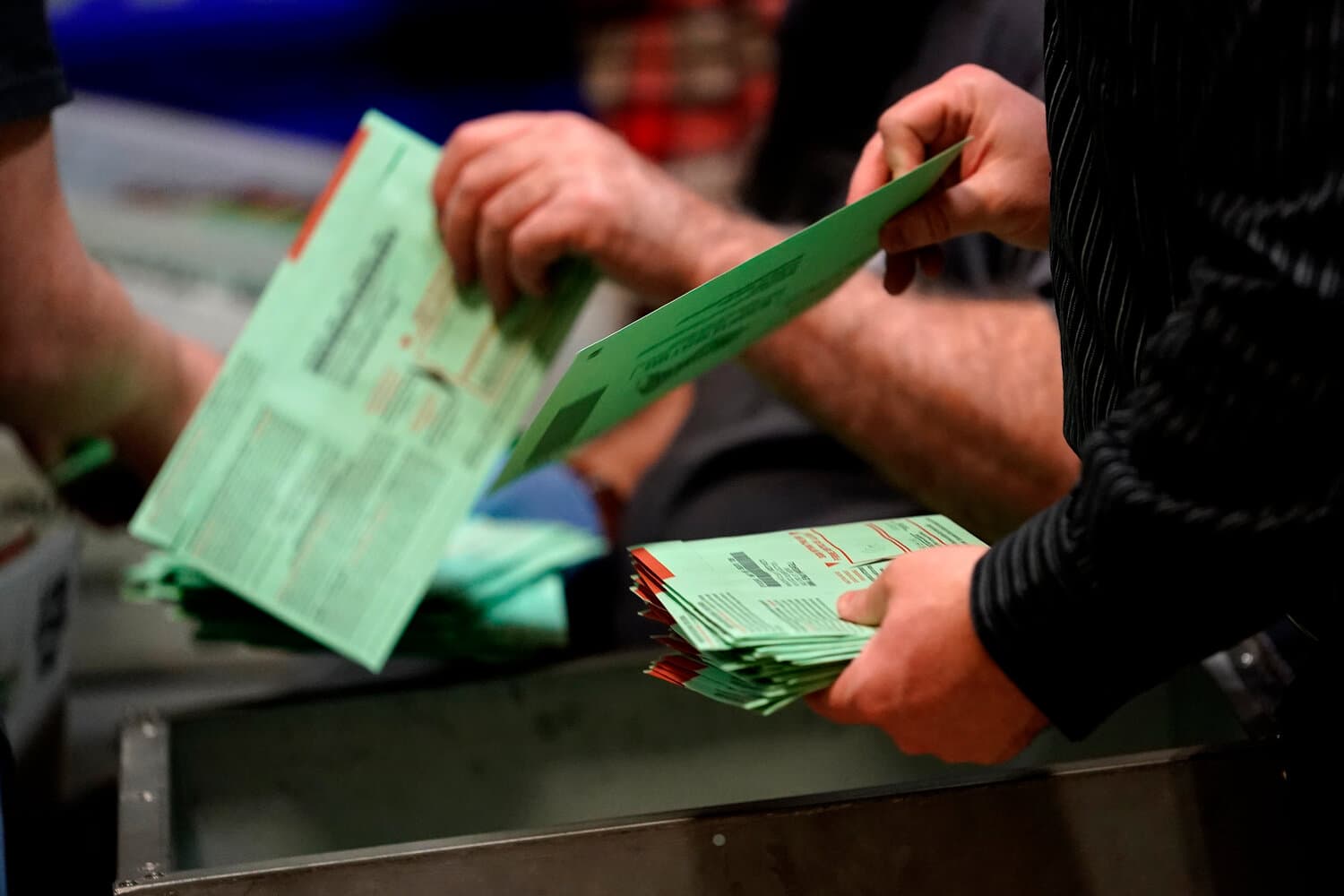 Ballots are handled and sorted during a local count as legal challenges surrounding Proposition 144 continue.