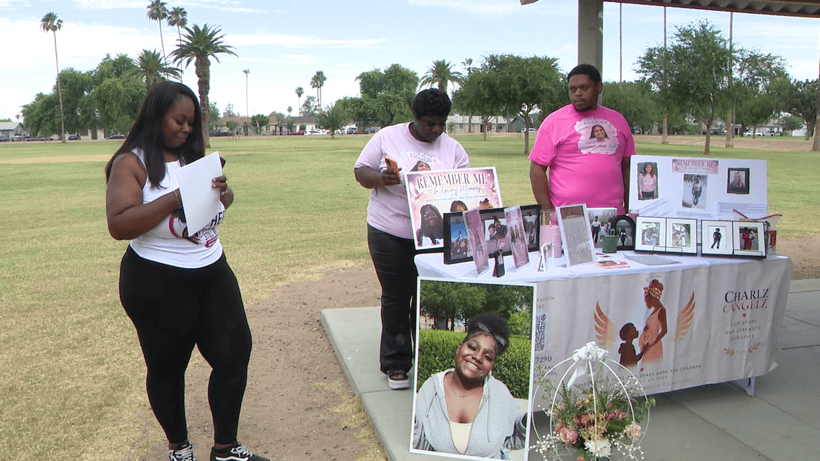 Family and community members arrange photos, flowers and a memorial table in a Phoenix park during the remembrance walk honoring Zariah Dodd one year after her murder.
