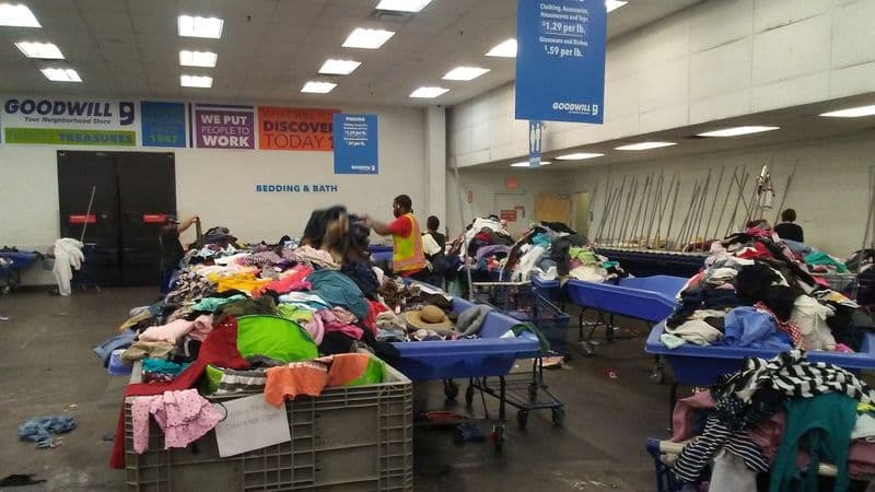 Shoppers sift through large bins of clothing at a Goodwill outlet, a popular 'treasure hunting' spot inside a sprawling Arizona shopping complex.