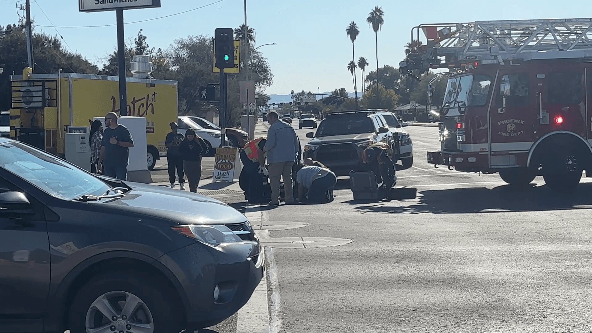 Phoenix emergency responders and a fire truck at the intersection as crews attend to a person on the ground following the crash that left a man dead.