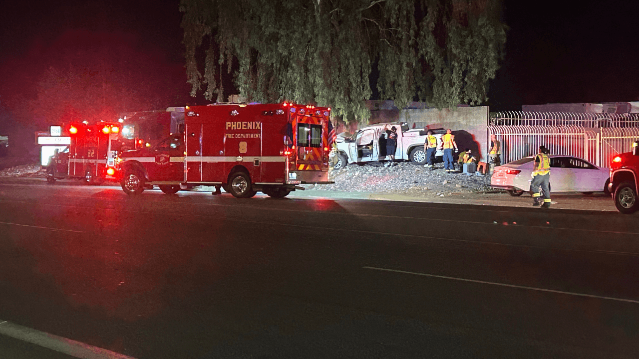 Phoenix Fire Department crews and emergency responders work at the scene after a vehicle crashed into a tree in Phoenix; three people were taken to a hospital in critical condition.