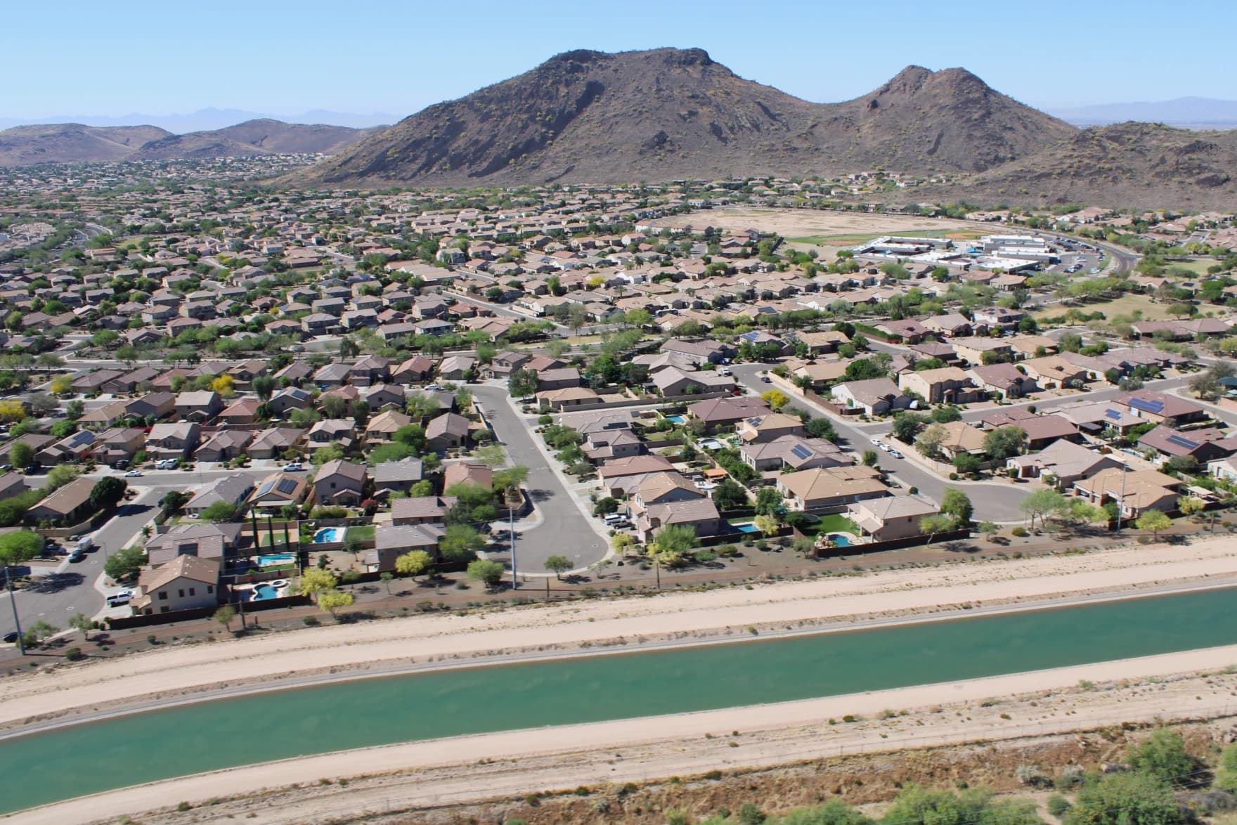 A canal running past Phoenix-area suburbs; Phoenix leaders approved a water-share program intended to help Arizona weather shortages on the Colorado River.