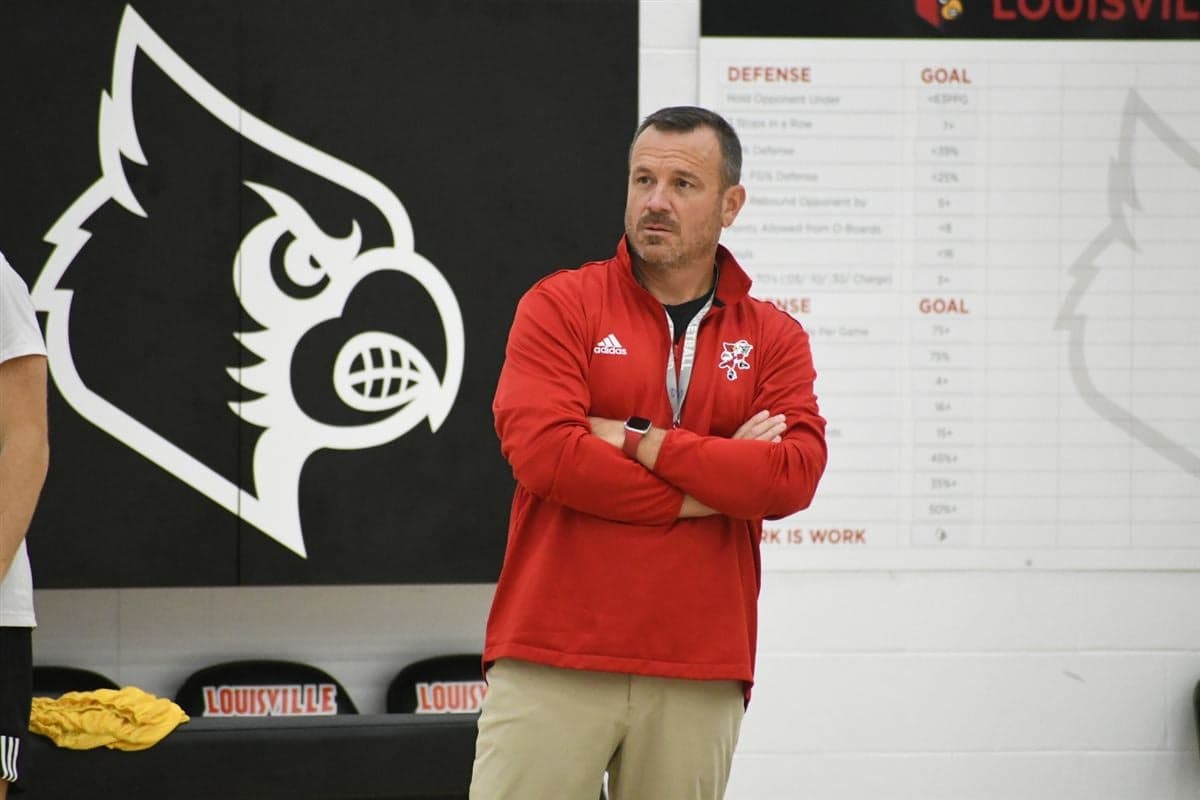 Louisville's head coach watches as players take part in summer workouts inside the Cardinals' practice facility.
