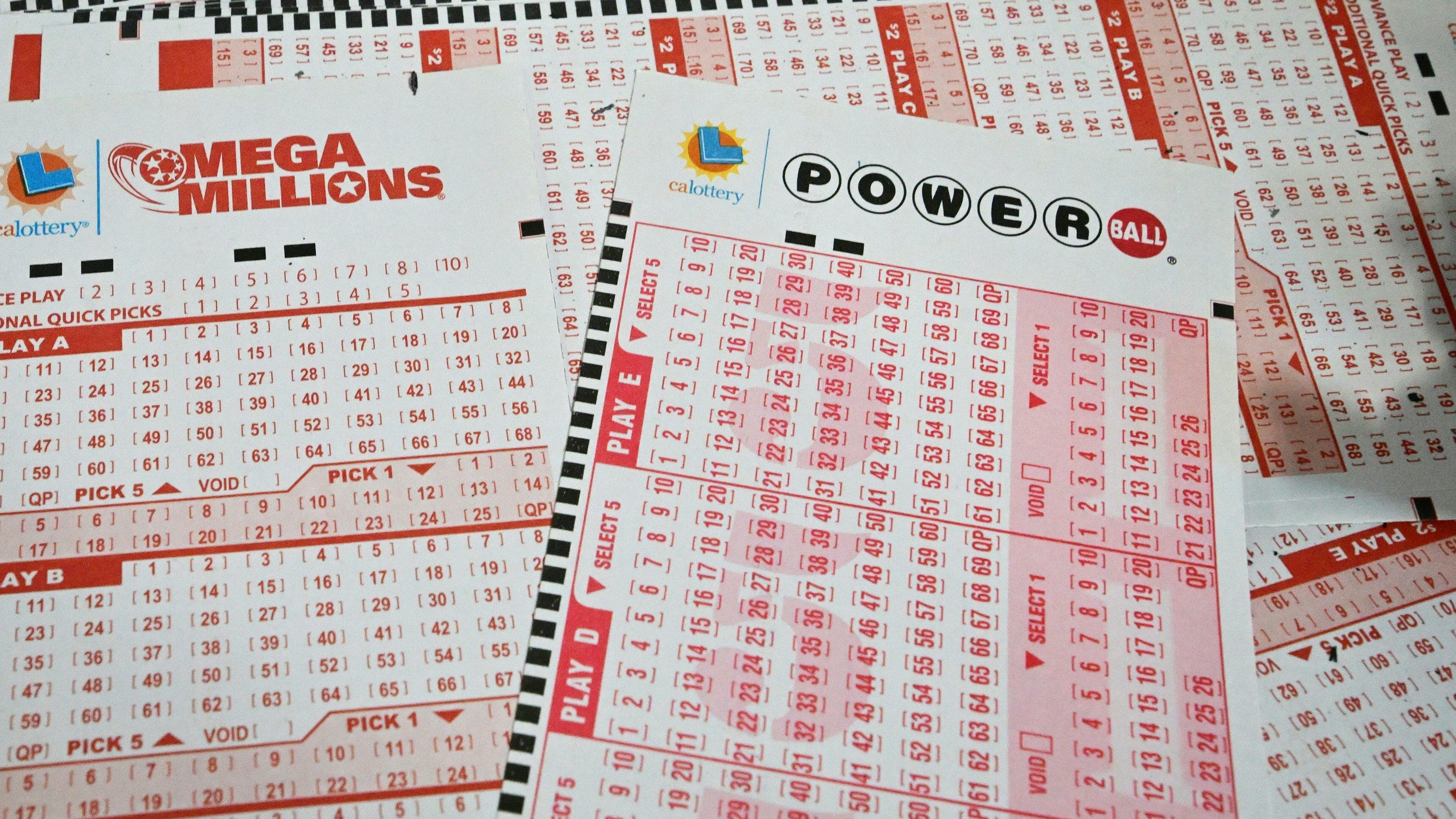 Powerball and Mega Millions play slips on a counter — check your Arizona Lottery tickets for the July 18, 2026 drawing.