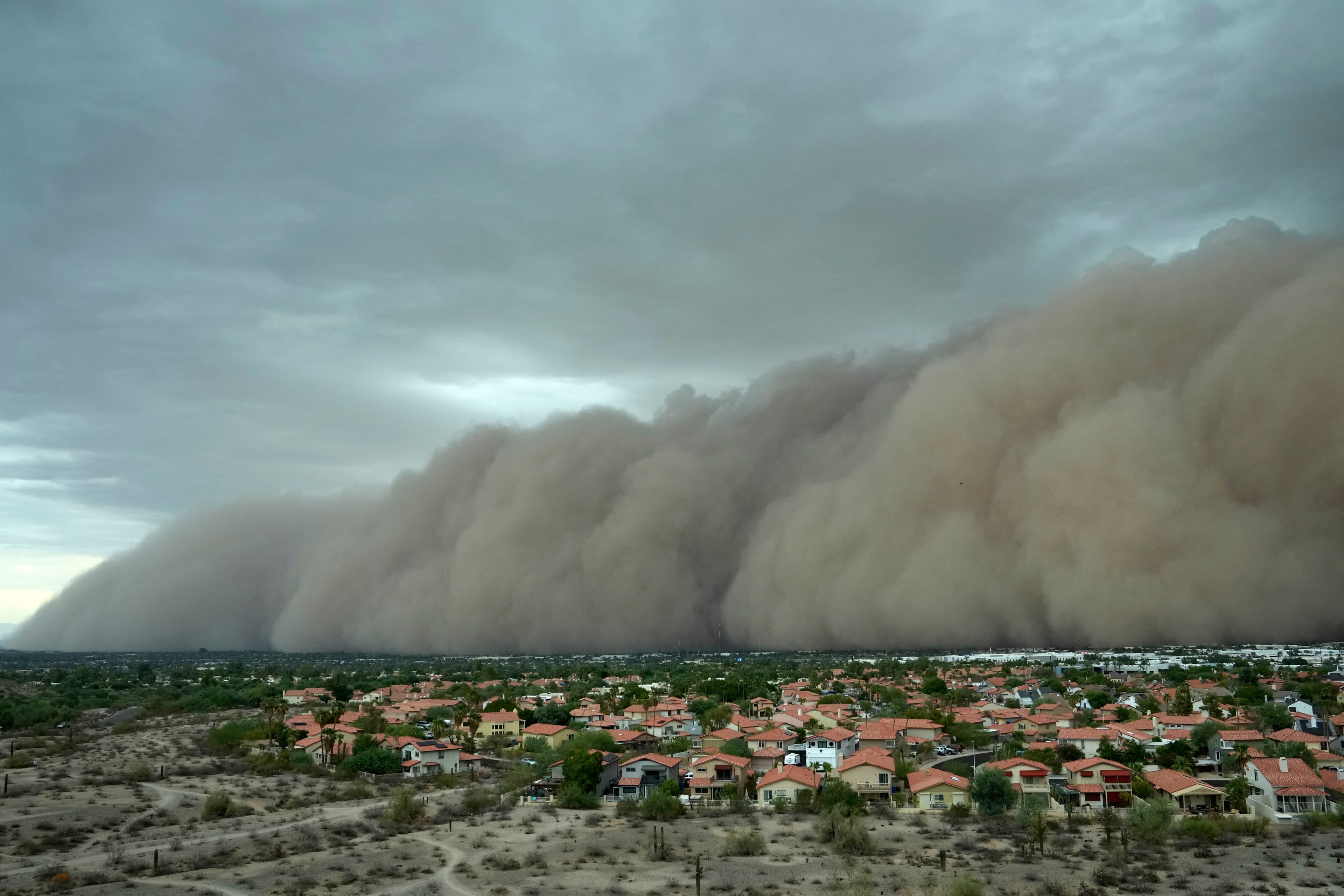 A massive dust wall (haboob) moves over Phoenix suburbs — the kind of sweeping dust event forecasters say could return for a second consecutive night.