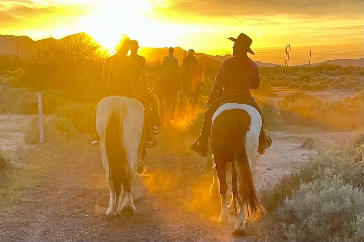 Riders move along a desert trail at sunset during a guided Koli Equestrian Center tour, part of the horseback journeys that explore Arizona’s Indigenous history.