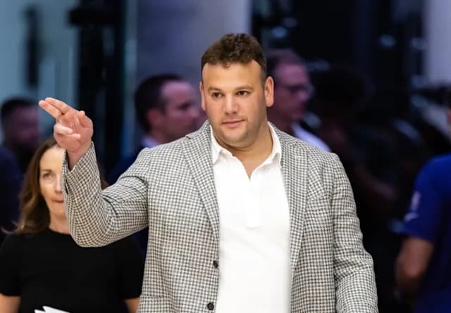 Shows: Phoenix Suns executive in a checked blazer gestures courtside during a recent game as fans react to the club’s CEO contract extension.