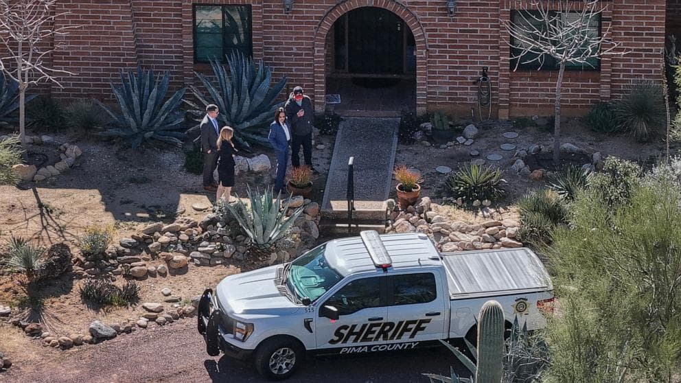 Pima County sheriff pickup and investigators at the front entrance of a Tucson home as law enforcement continues the search for the missing woman.