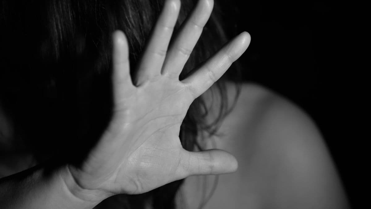 Representative image of a woman shielding her face, illustrating domestic violence in coverage of an Arizona man charged in his girlfriend’s death after he called 911.