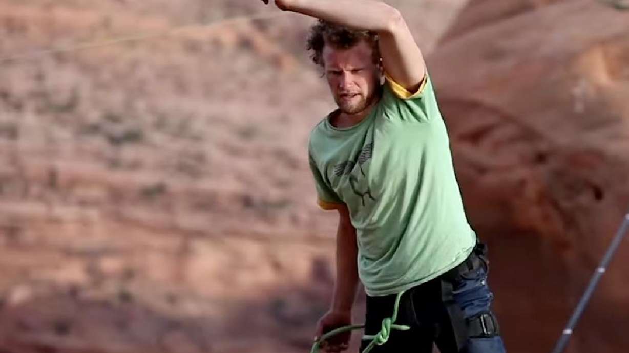 A climber rigs rope on red-rock sandstone in southern Utah; outdoor community members are mourning the recent death of a prominent local slackliner and adventurer.