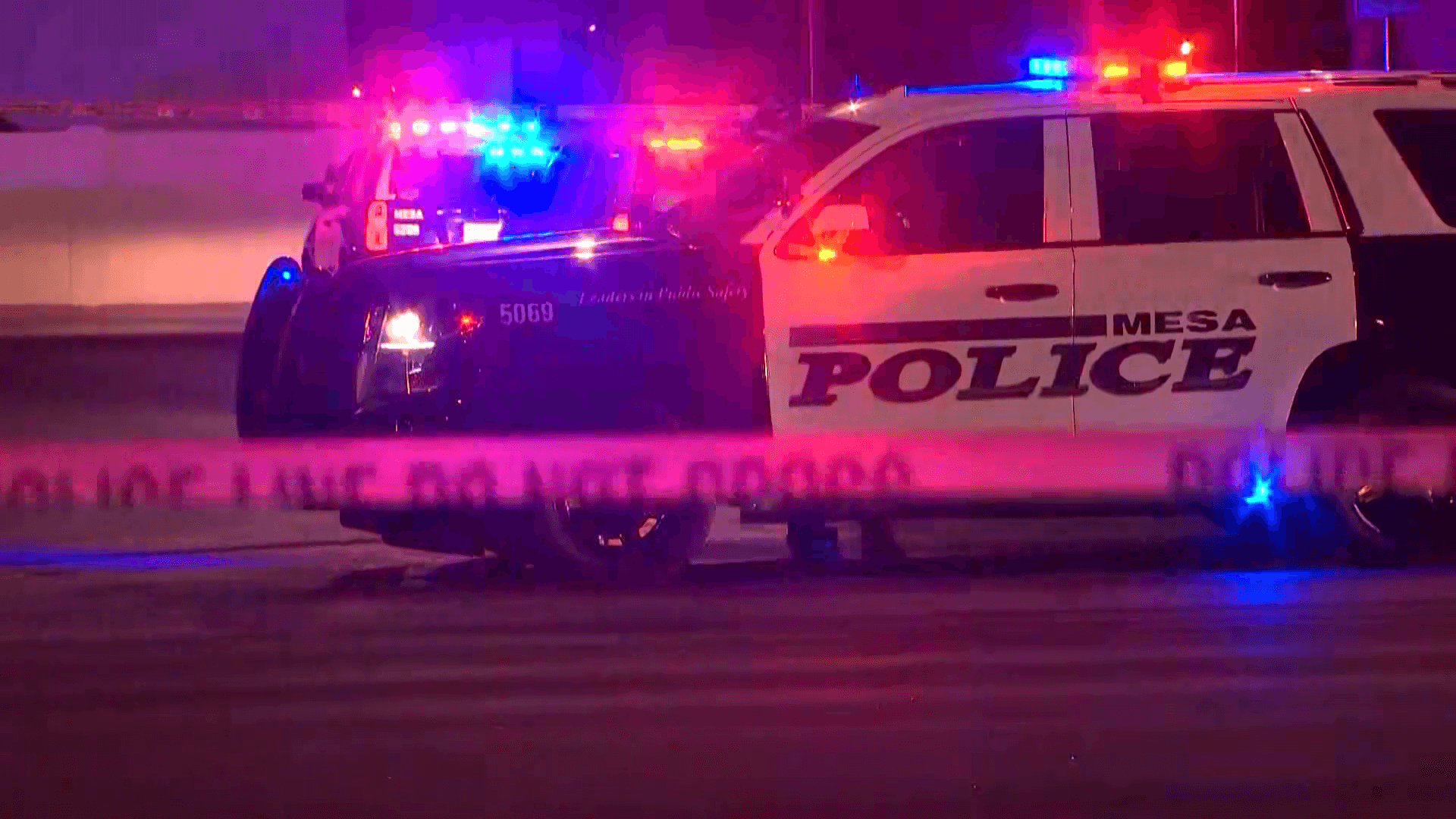 Mesa police cruisers with emergency lights and police tape at a nighttime scene; Mesa is among the Phoenix-area cities that have reported recent murder-suicide incidents.