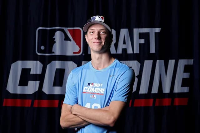 A draft prospect poses in front of the MLB Draft Combine backdrop after being selected in the 2026 MLB Draft.