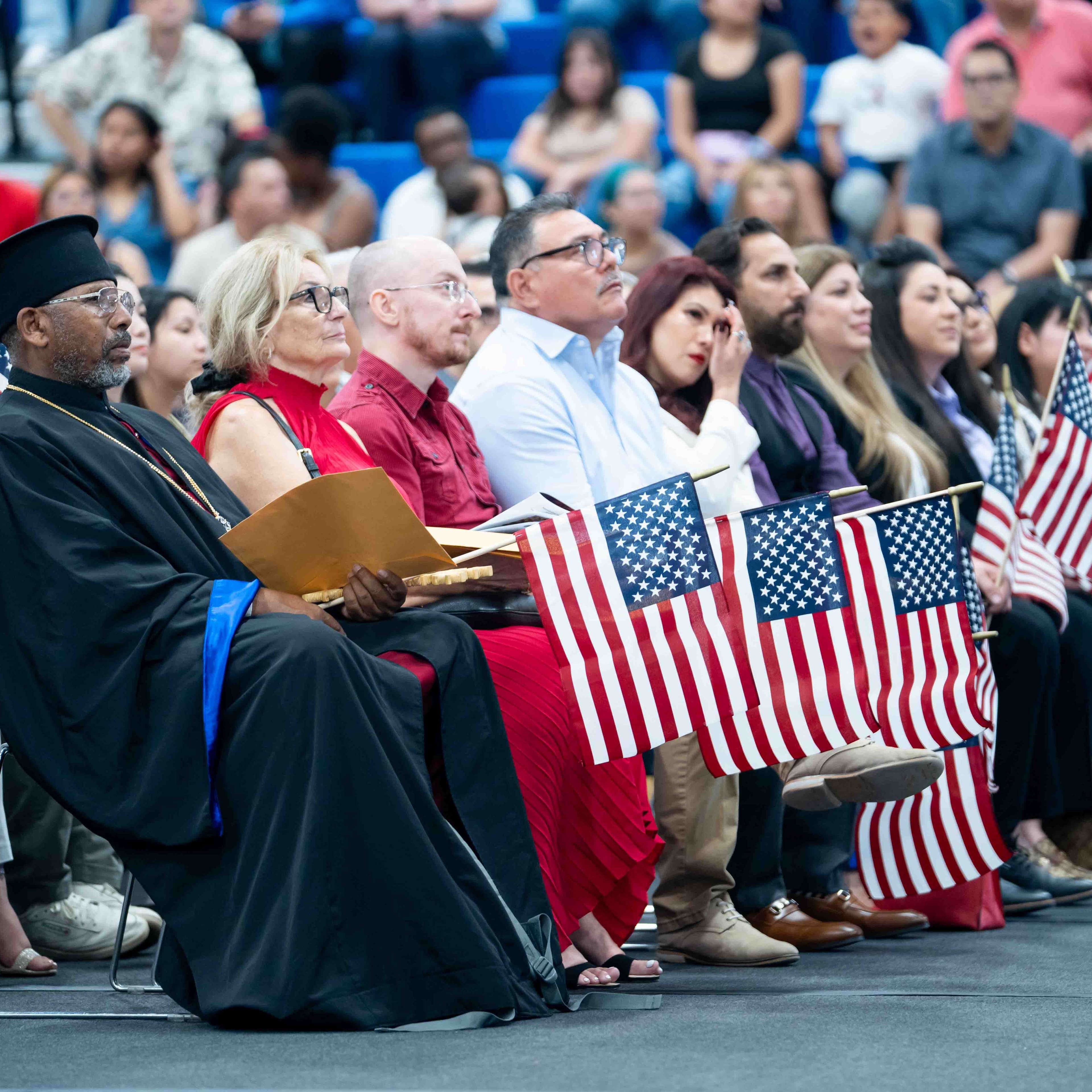 Attendees and family members hold small U.S. flags during the July 4 naturalization ceremony at Saguaro National Park, where 15 people took the Oath of Allegiance to become U.S. citizens.