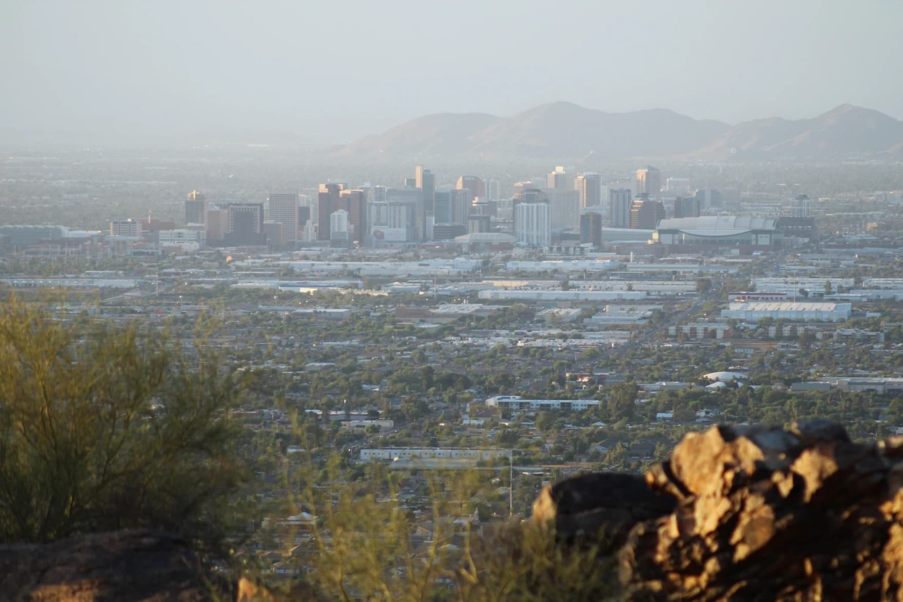 Downtown Phoenix and surrounding suburbs at dusk — Arizona cities are pressing for answers about Colorado River water held in underground storage.