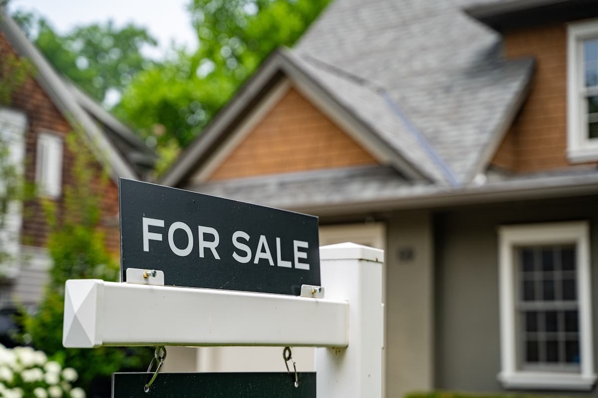 A 'For Sale' sign in front of a single-family home, illustrating the housing market pressures and rising prices underlying Flagstaff’s affordability challenges.