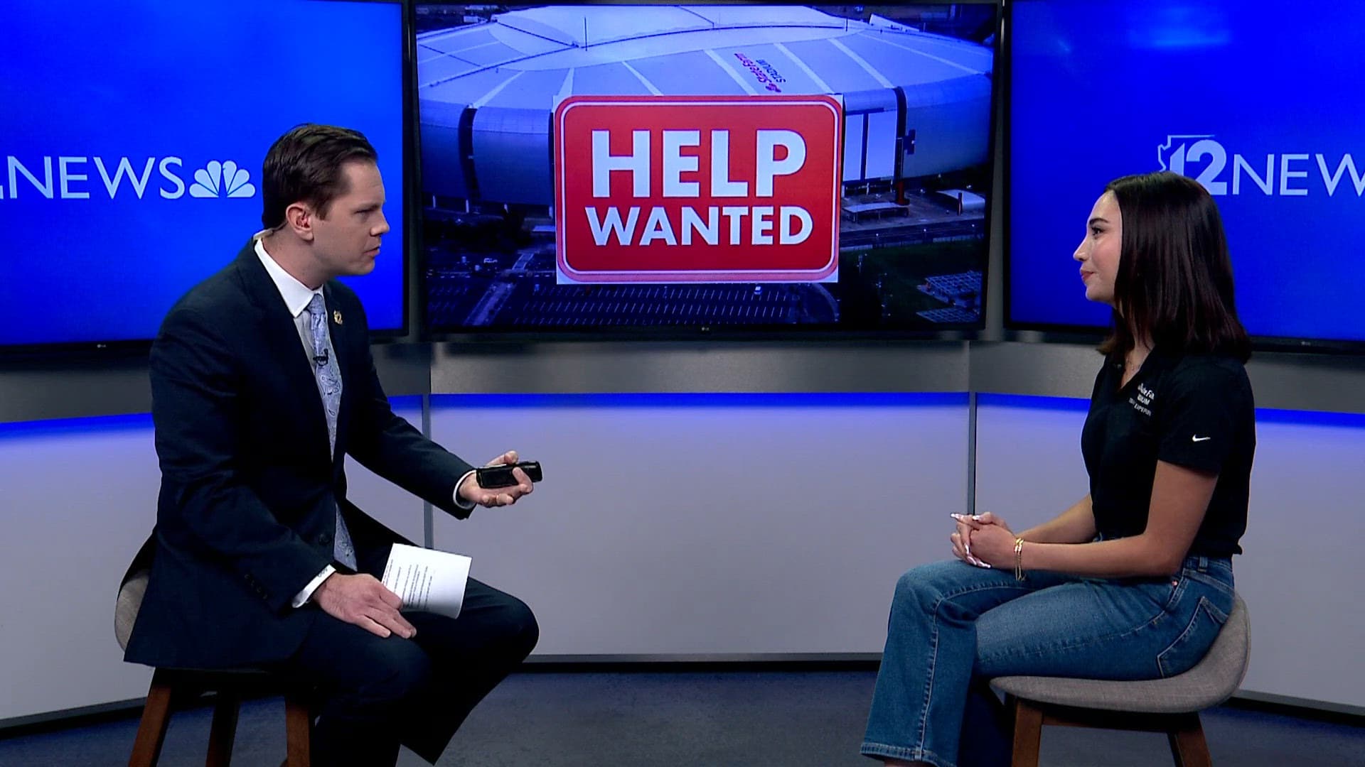 Shows: In-studio 12News interview promoting the State Farm Stadium job fair, with a 'HELP WANTED' graphic displayed over an image of the stadium on the monitor.