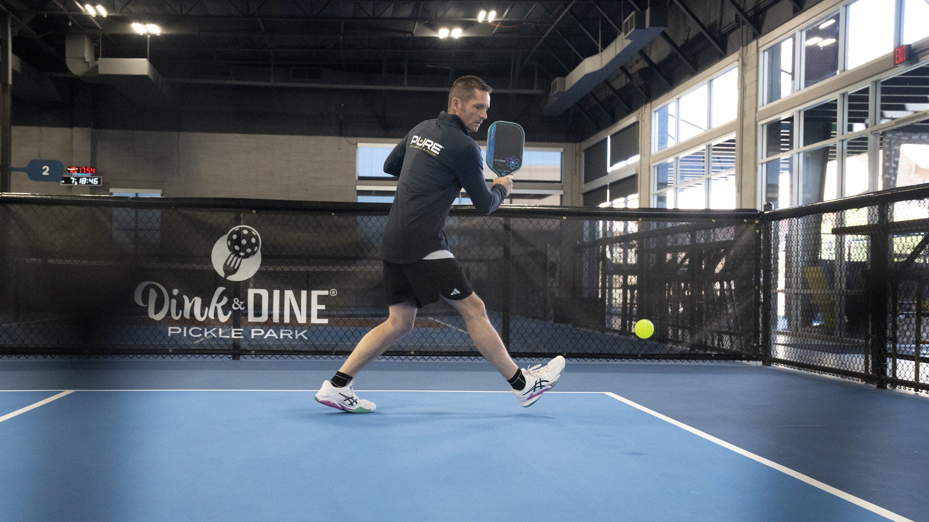 The five-time national pickleball champion referenced in the story returns a shot at Dink & Dine Pickle Park in Arizona during a coaching session tied to his effort to expand pickleball clubs in local schools.